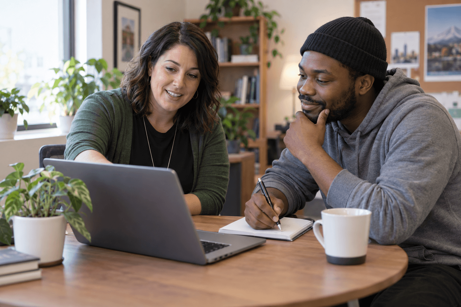 An employment specialist and a client reviewing a job listing together on a laptop