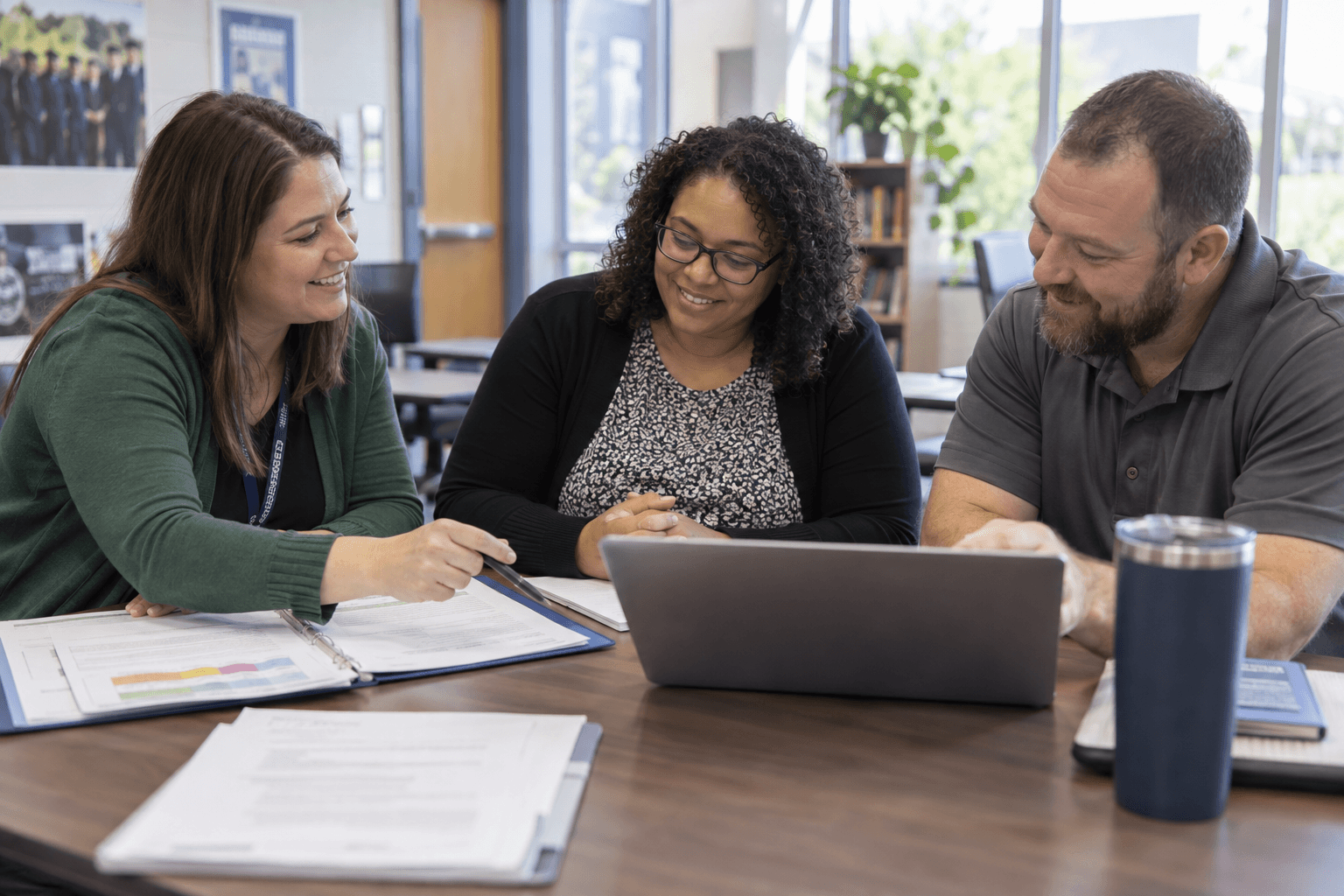 A school transition coordinator, an agency case manager, and an employer planning together in a school conference room