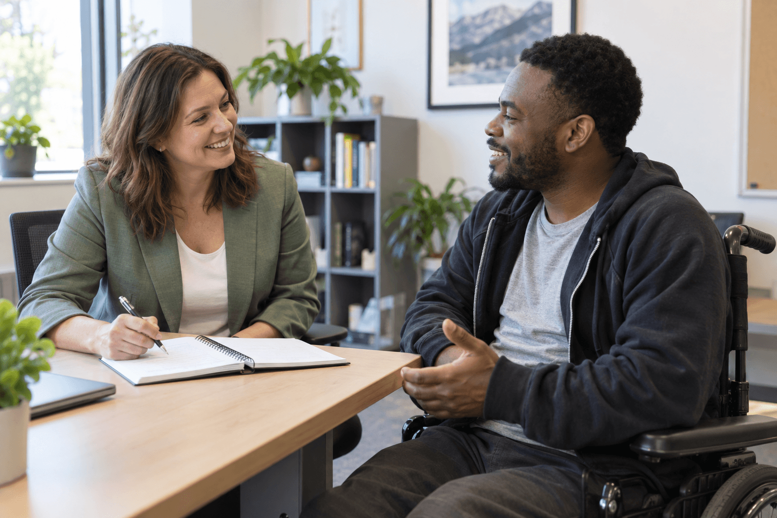 A vocational rehabilitation counselor talking through goals with a client in a bright office